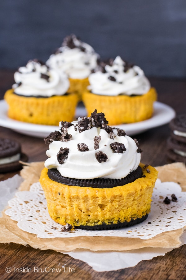Mini pumpkin oreo cheesecakes with cool Whip and cookie crumbs on top