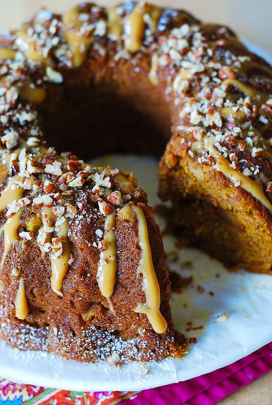 Apple Pumpkin Cinnamon Vanilla Bundt Cake drizzled with dulce de leche and top with chopped pecans