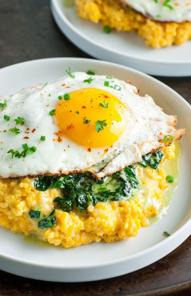 Creamy cheese grits swirled with brown butter and pumpkin topped with sunny side up egg 