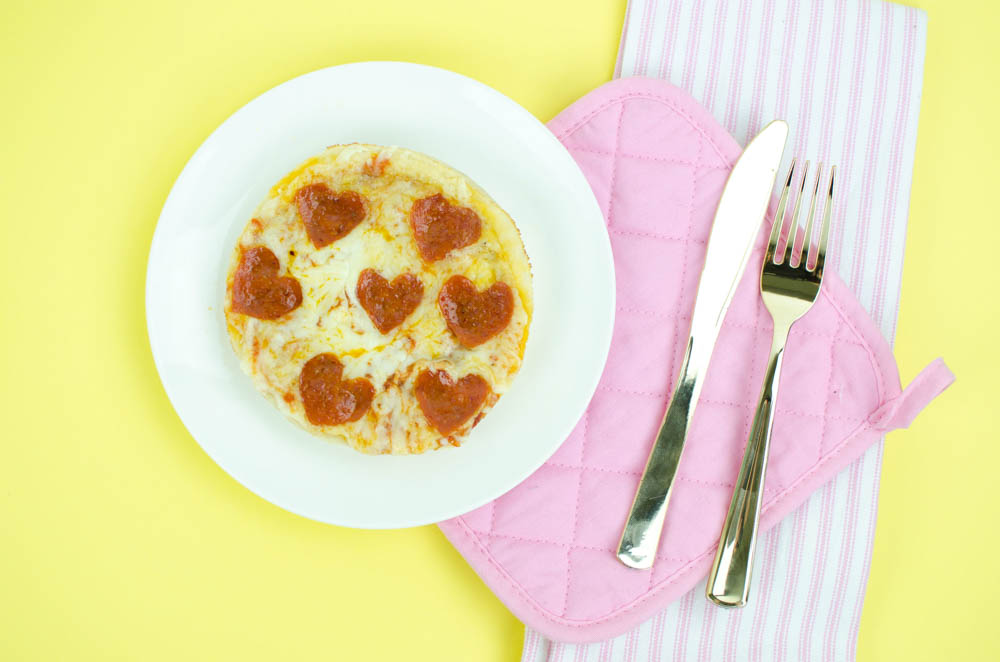 Punny valentine's day pizza topped with heart shaped pepperoni 