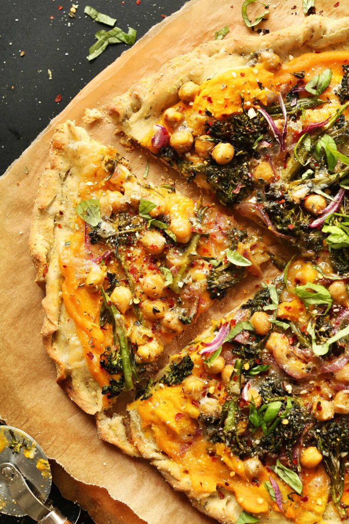 Butternut squash veggie pizza served with parmesan cheese, dried oregano, and red pepper flakes.