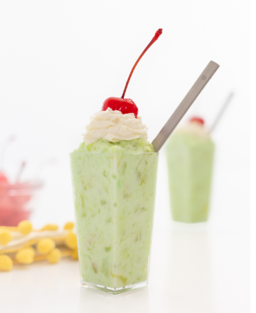 Pistachio dessert pudding with crushed pineapple. Added with whipped cream and cherry on top