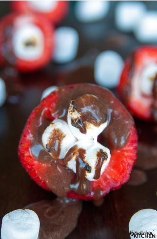 Smores stuffed strawberries poured with chocolate syrup