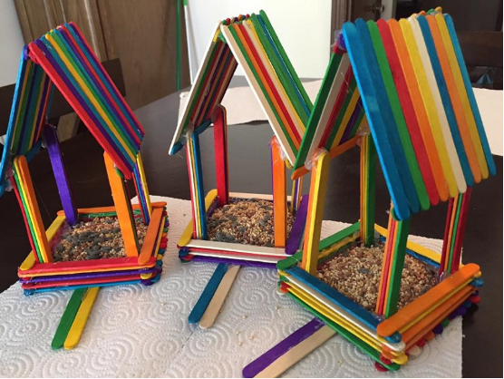 A colorful and homemade rainbow popsicle stick birdhouses 