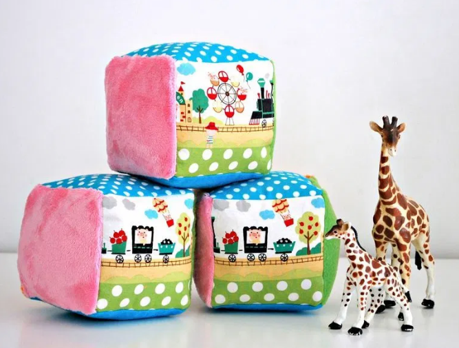 Three soft rattle blocks each blocks has a variety of colors, designs, and textures and two cute little giraffe