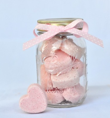 Heart shape bath bombs inside a mason jar with a pink ribbon on it.