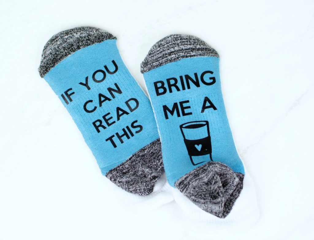 A pair of socks with text saying If you can read this and the other one is a Bring me a and an image of a coffee
