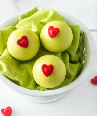 green with red heart grinch themed hot cocoa bombs