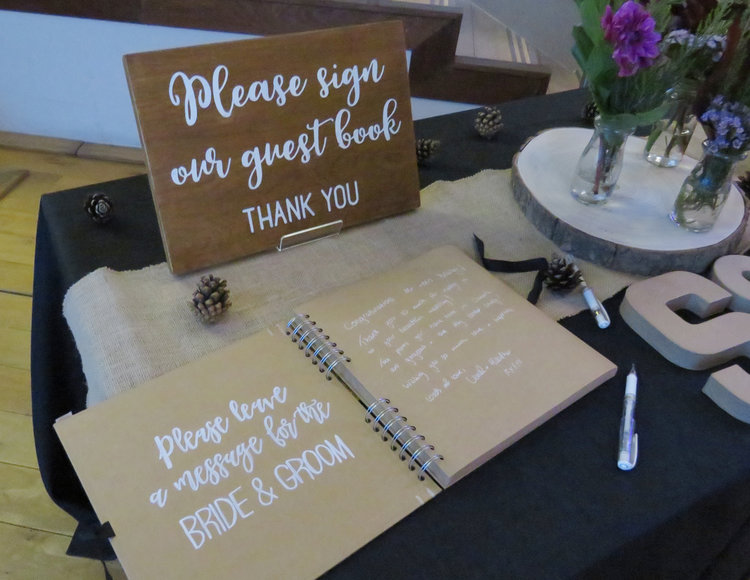 A placa de casamento de madeira diz: Por favor, assine nosso livro de visitas, obrigado.