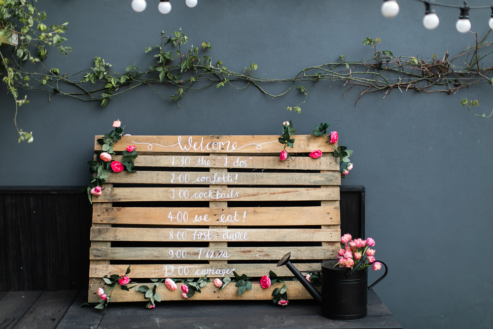 Placa de casamento em palete de madeira que indica a programação do casamento