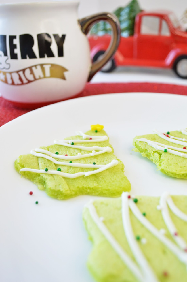 Christmas tree pancakes drizzled with frosting and top with sprinkles