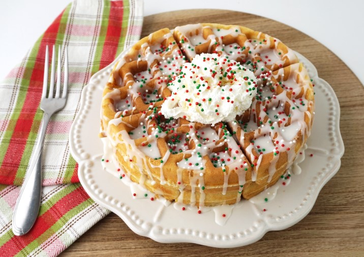 Fluffy Sugar Cookie Waffles top with sprinkles and whipped cream for a festive Christmas morning breakfast