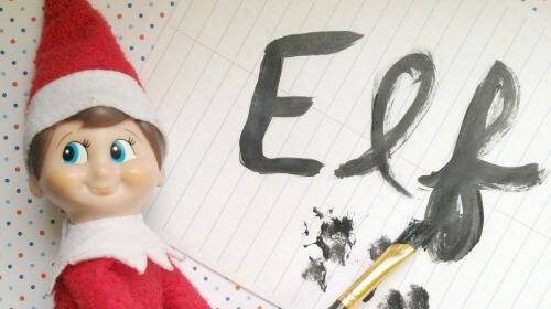 elf on the shelf holding a paintbrush and ready to paint