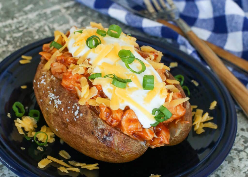 BBQ Chicken Stuffed Baked potatoes garnished with cheese, sour cream and chives