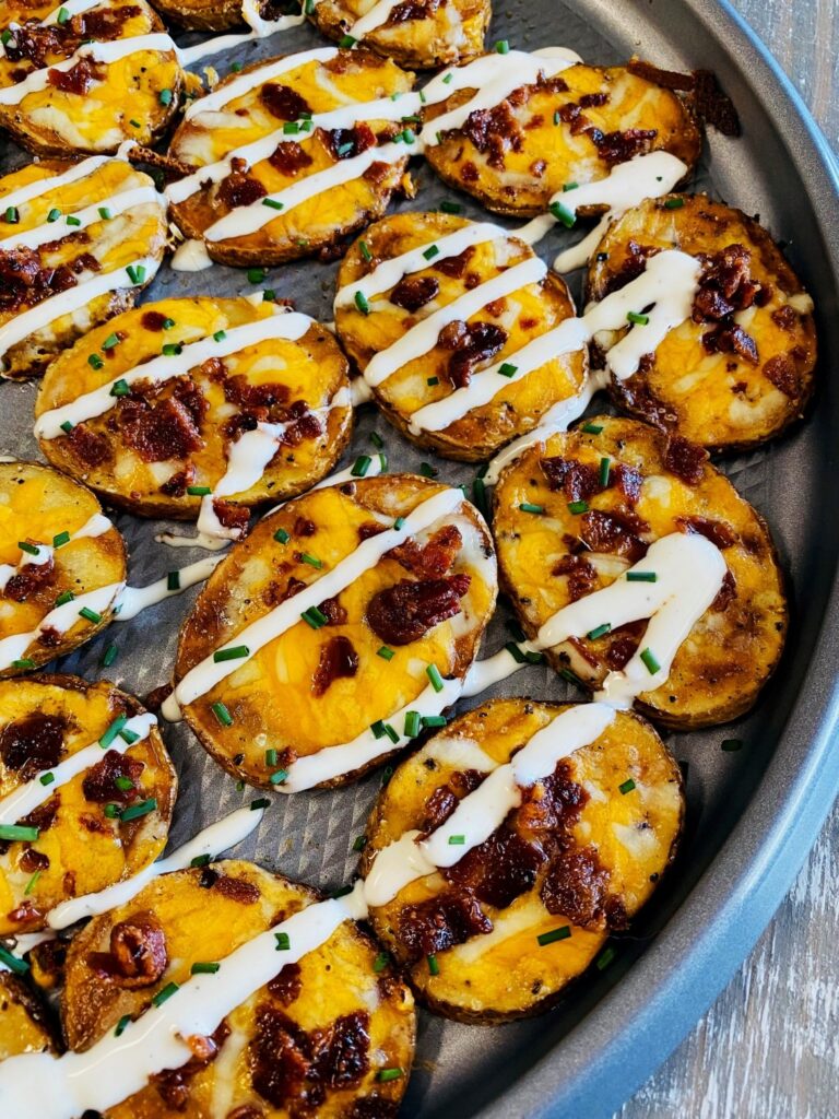 Sliced potatoes cooked on the Blackstone Griddle and topped with cheese and bacon