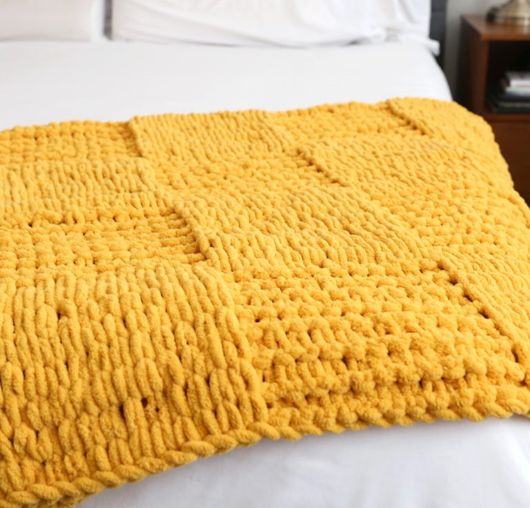 Finger knitted textured checkerboard blanket 