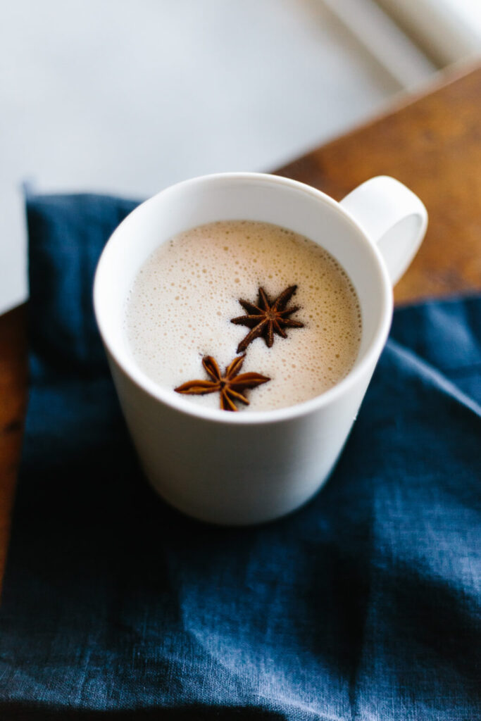 A mug of Chai spiced coconut milk garnished with whole star anise
