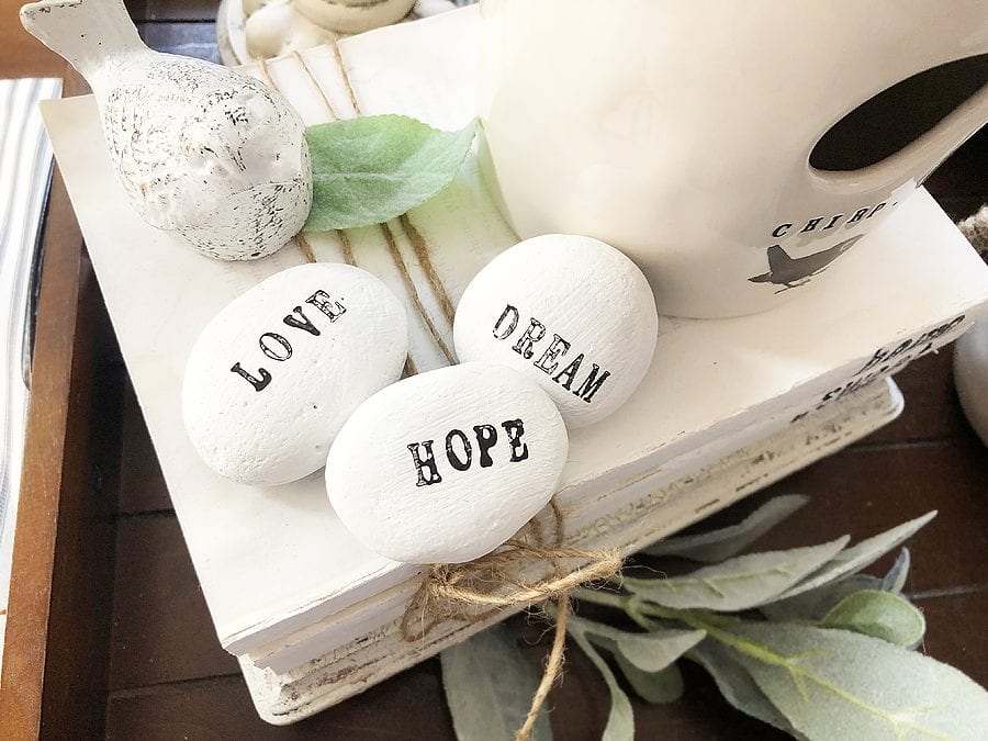 Painted word stones. one has a word LOVE, 2nd has a word HOPE and the 3rd one has a word DREAM