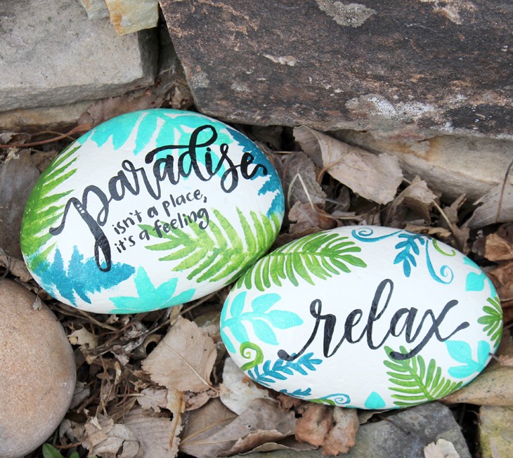 Tropical design painted rocks with a text paradise isn't a place it's a feeling, and relax