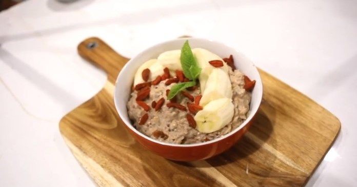 A bowl of ancient grain porridge topped with sliced bananas and goji berries