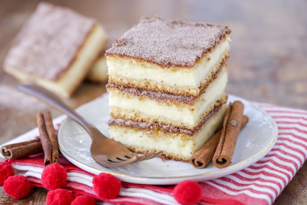 churro cheesecake bars covered in cinnamon and sugar filled with a sweet cream cheese layer