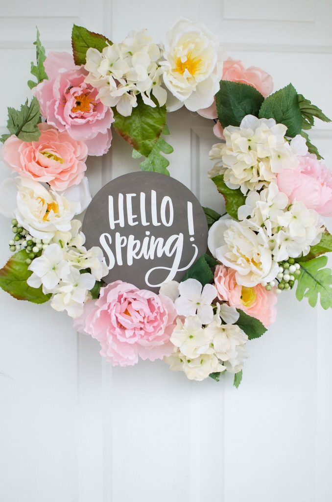 DIY spring wreath using Cricut it has a text at the middle saying Hello Spring