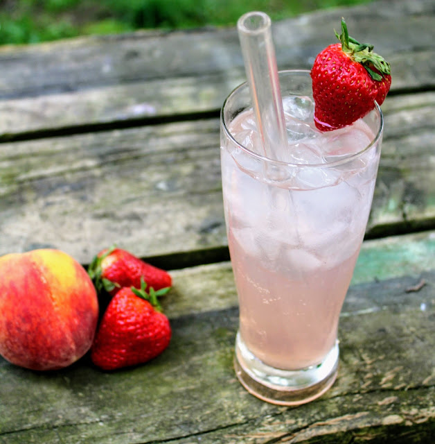 Homemade Strawberry Peach Soda garnish with a fresh strawberry perfect for a summer day