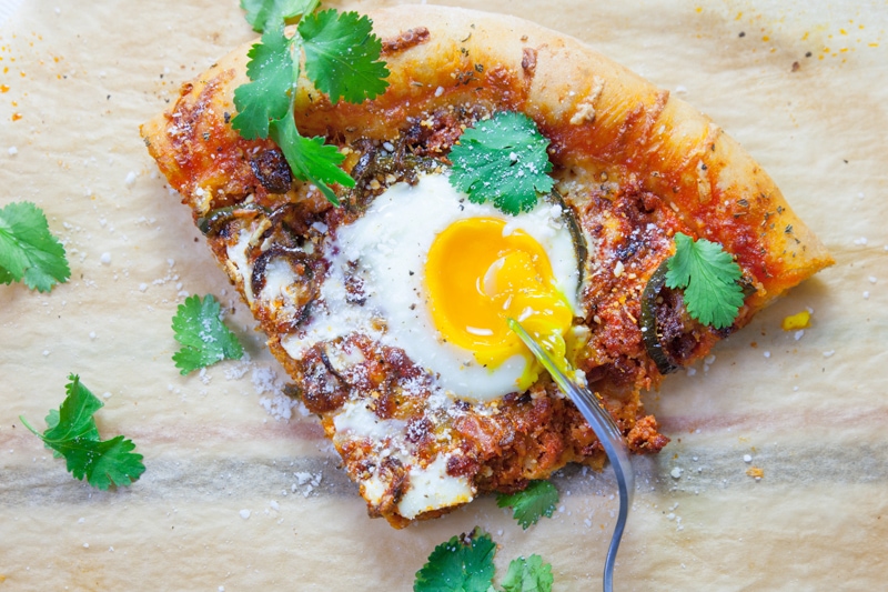Slice of Chorizo Breakfast Pizza with an egg cooked on top