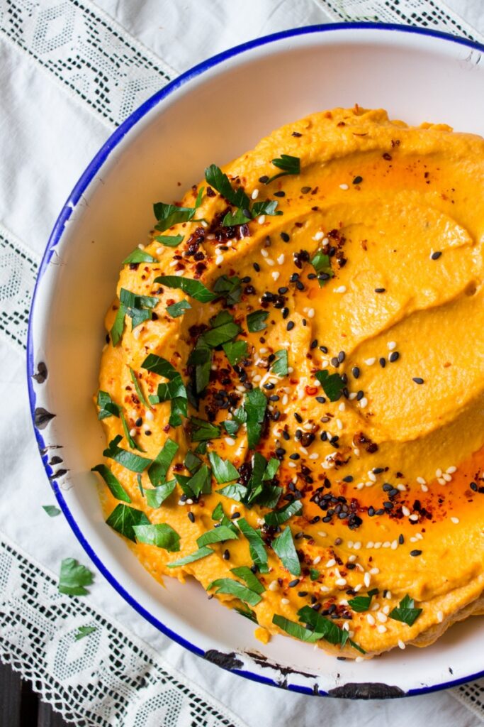 pumpkin hummus sprinkle with sesame seeds and fresh herbs