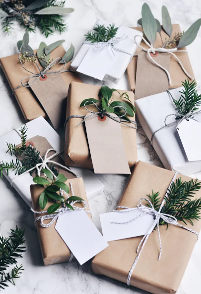 Festive gift wrapping with festive foliage under each bow