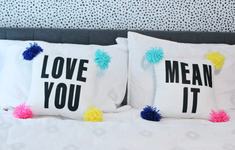 DIY pom pom pillow with text saying Love You and Mean It